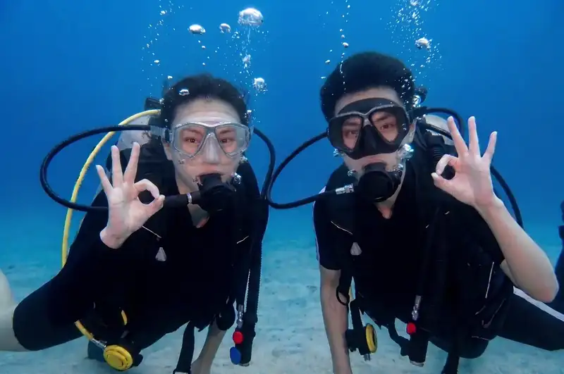 A professional dive buddy guiding guest with Coco Seaweed Resort near Semporna and the Celebes Sea.